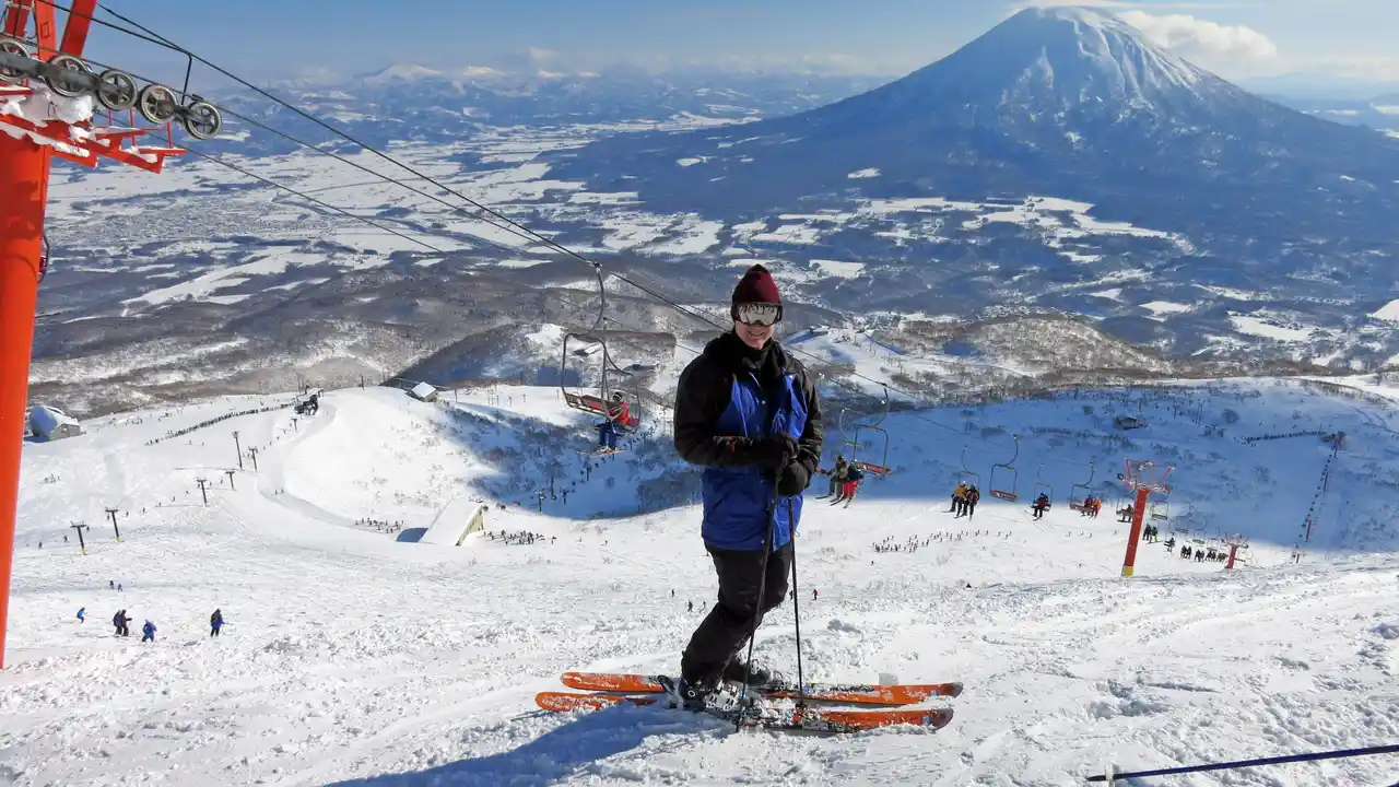 Close up on a plate of mashed potatoes, topped with baked pork chops with cream of mushroom soup, and a side of green beans.